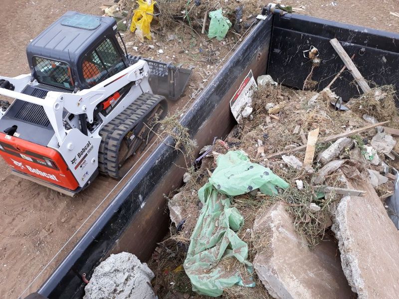 rubbish in bin bobcat on side